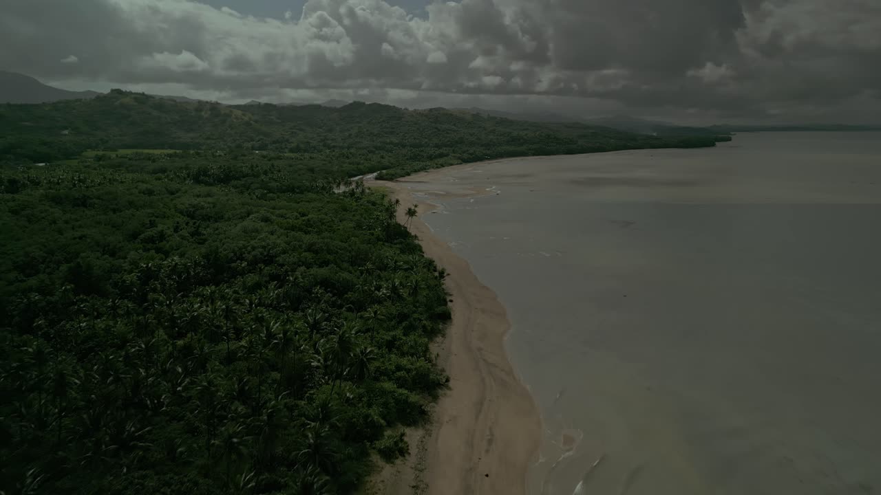 bosque y playa de arena por el mar tranquilo en las nubes de filipinas, amplia antena