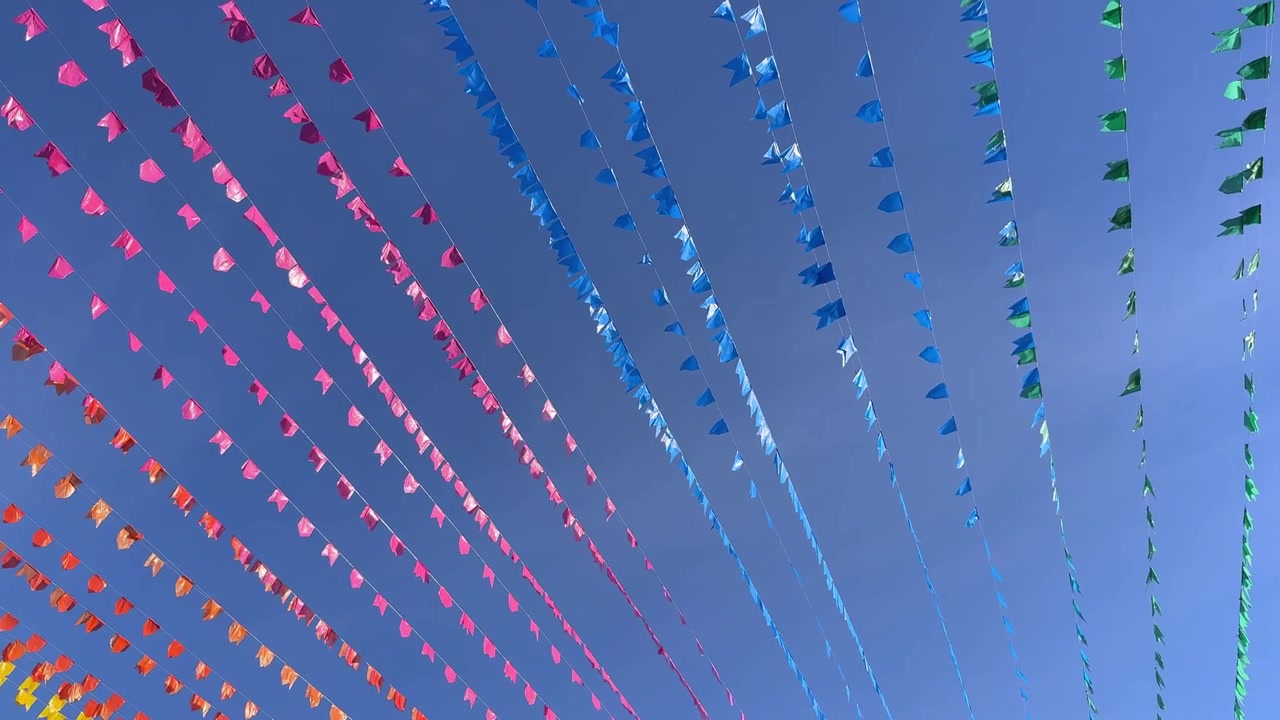 Bandierine colorate che ondeggiano contro un cielo azzurro limpido