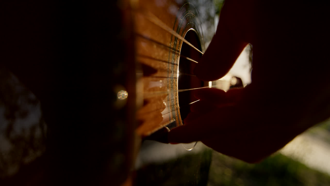 Person playing acoustic guitar outdoors