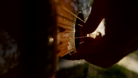 person playing acoustic guitar outdoors