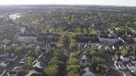 summer sunrise arial rise fly over calgary suburb of inverness town of mckenzie highands residential community of low rise town homes detauched apartments by manmade ponds parks promenade way ab can