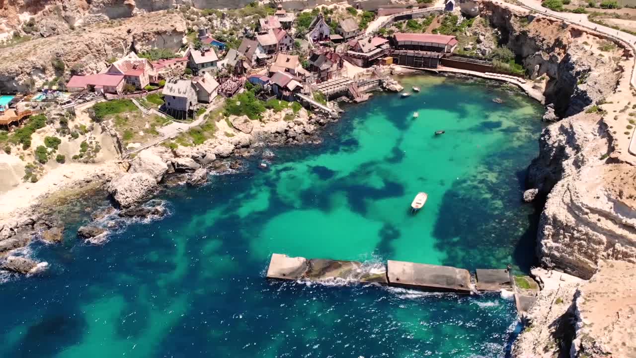 Popeye village aerial drone shot, birds eye, fly backward. Film village for movie Popeye. Malta.