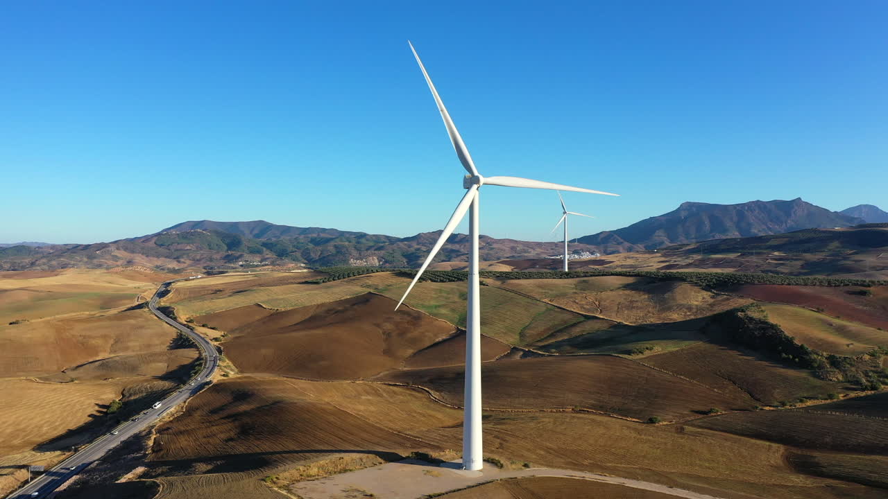 vista aérea de una enorme turbina eólica cerca de la autopista que muestra la escala de estas grandes turbinas eólicas, fuente alternativa de energía renovable