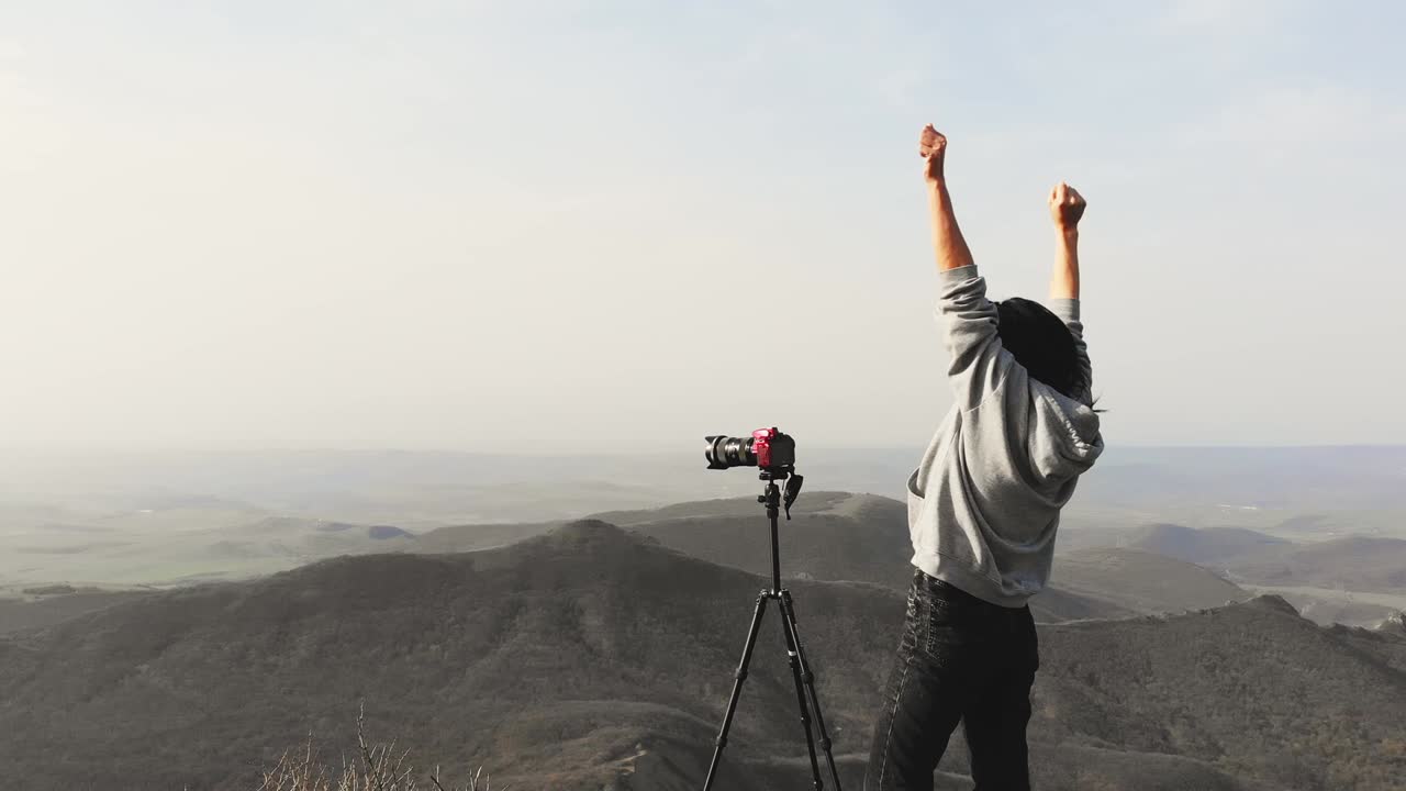 atractivo caucásico fotografiando montañas con dslr con alegría