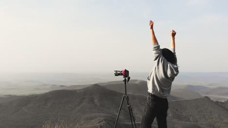 zoom out view attractive caucasian photographing mountains with dslr with joy