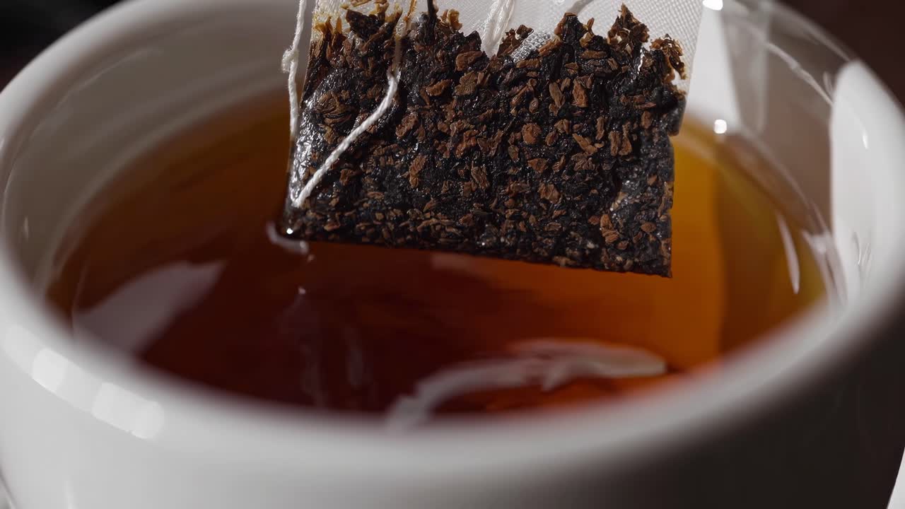 Primo piano di una bustina di tè in infusione in acqua calda
