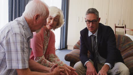 senior couple talking with a business man in retirement house