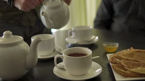 people enjoying tea and crepes in a cafe
