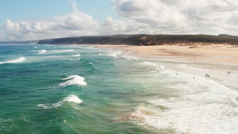 Toma-Aérea-De-Una-Playa-De-Arena-En-Portugal-Con-Olas-Rompiendo-A-Lo-Largo-De-La-Costa