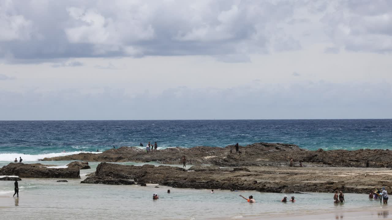 Persone che si godono una giornata di sole su una spiaggia rocciosa