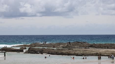 people enjoying a sunny day at a rocky beach