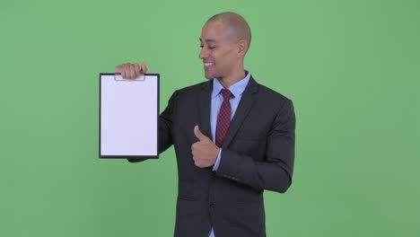 happy handsome bald multi ethnic businessman with clipboard