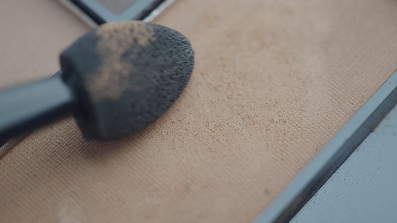 Makeup Sponge Dabbing Beige Powder in Cosmetic Palette