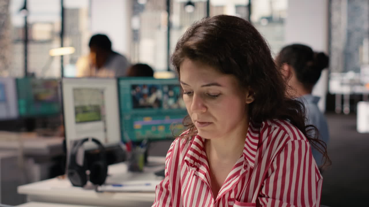 Donna concentrata che lavora al laptop in un moderno ambiente d'ufficio
