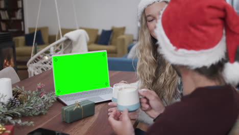 feliz pareja caucásica teniendo navidad llamada de video portátil con pantalla verde, cámara lenta