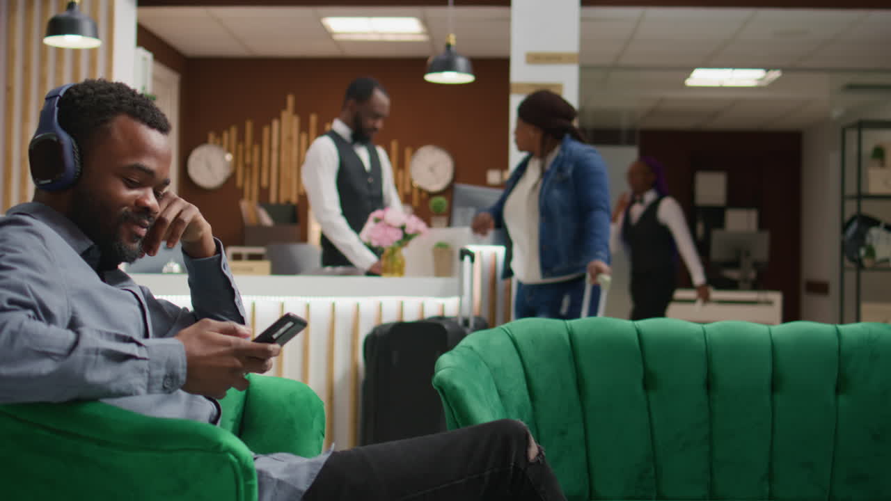 el huésped del hotel escucha música en los auriculares