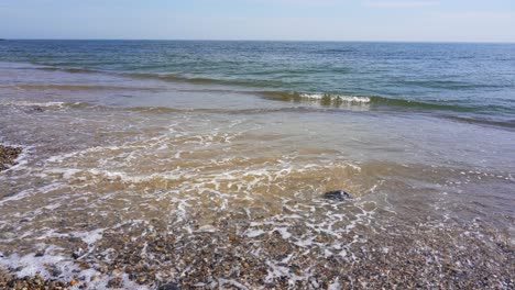 small waves gently lap the pebble beach at branscombe in devon, part of the unesco world heritage site of the jurassic coast