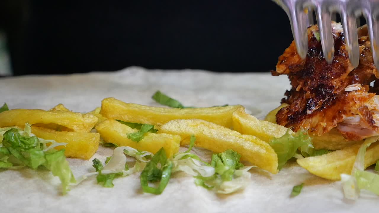 Preparing a shawarma wrap with fries, meat, and lettuce