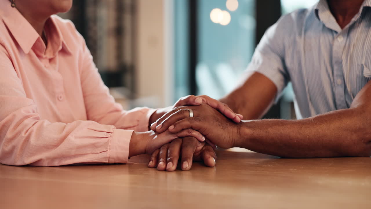Couple holding hands in a supportive gesture