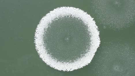 amazing nature drone aerial shot frozen snowy circles zoom out geometric patterns in frozen lake - winter cold weather