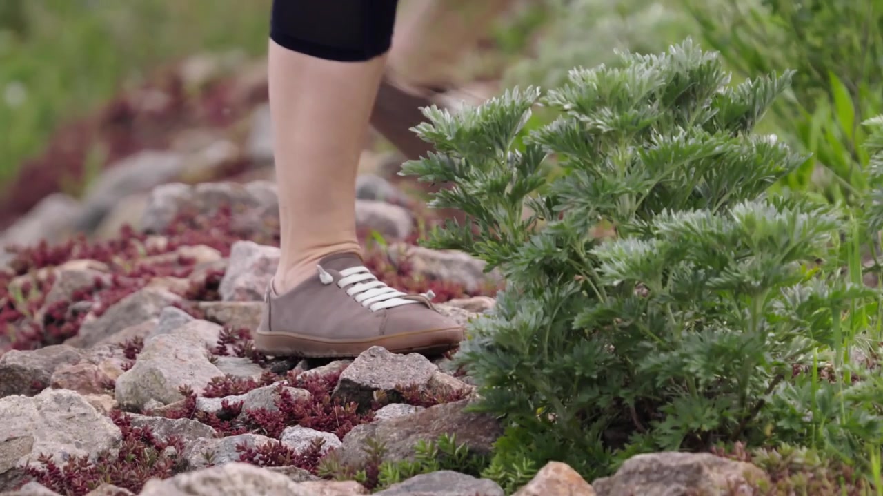 Close-up of a hiker's feet walking uphill on a rocky path