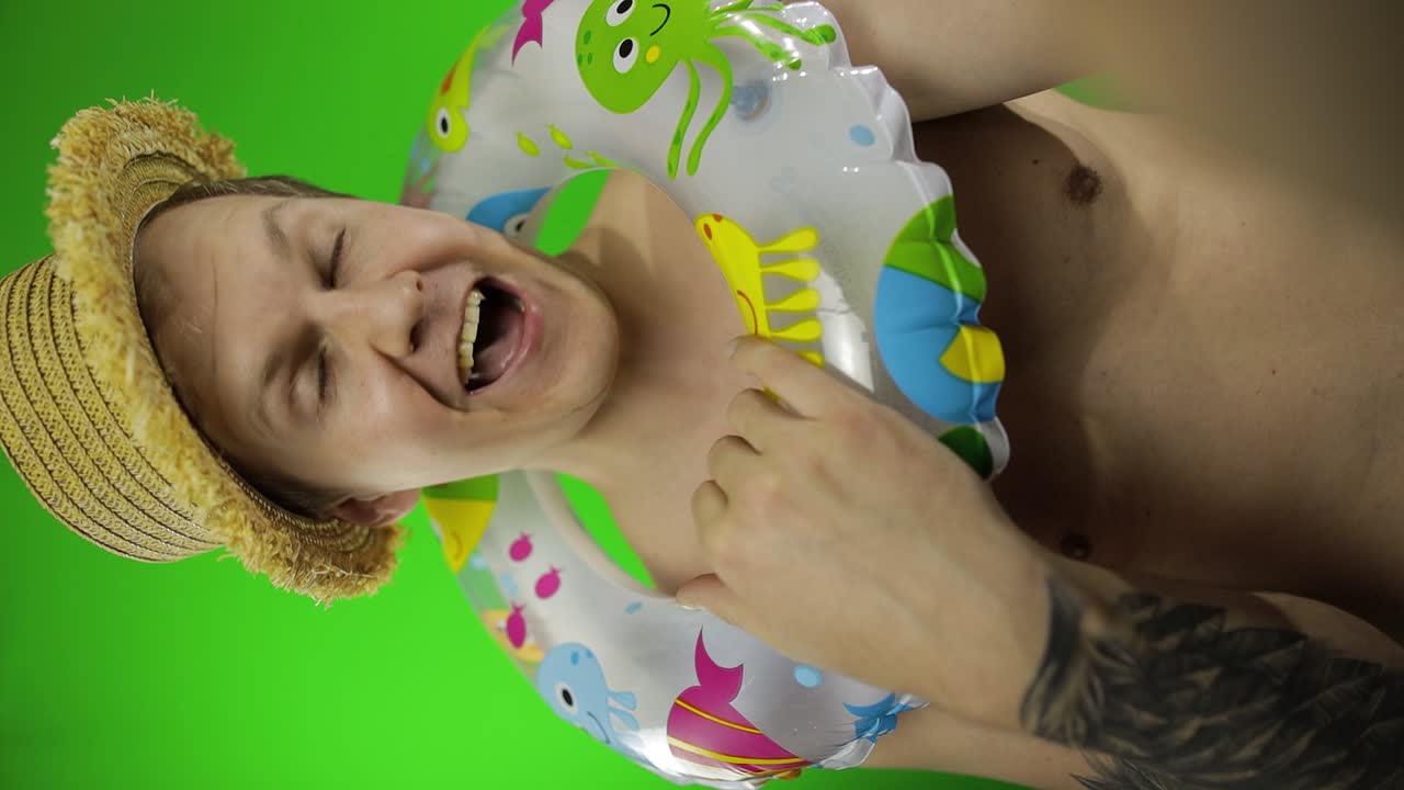 tomada vertical de un hombre sin camisa haciendo una selfie, llamada de video con anillo de natación