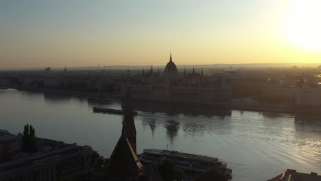 Cinematic-drone-shot-of-the-Hungarian-Parliament-Building-in-Budapest-Hungary,-into-the-sun