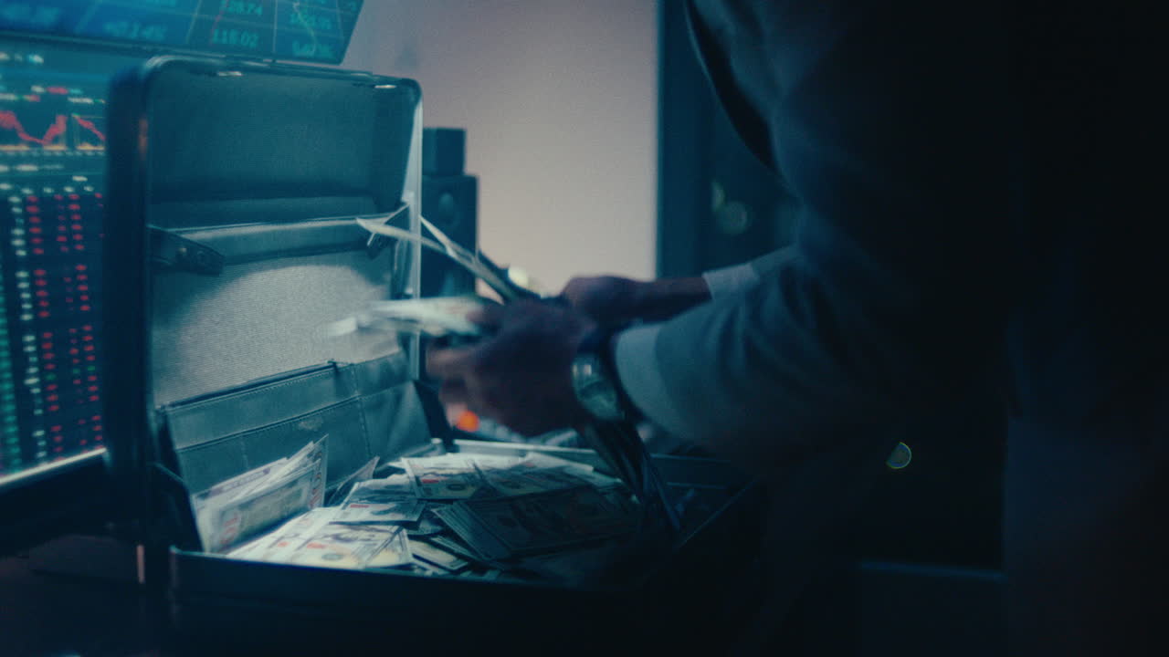 A cinematic shot of a professional investor's hands reaching into an open briefcase filled with bundles of one hundred dollar bills, set against a backdrop of financial data screens