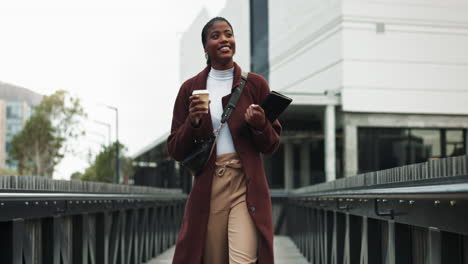 a woman walking down the street in the city with a coffee