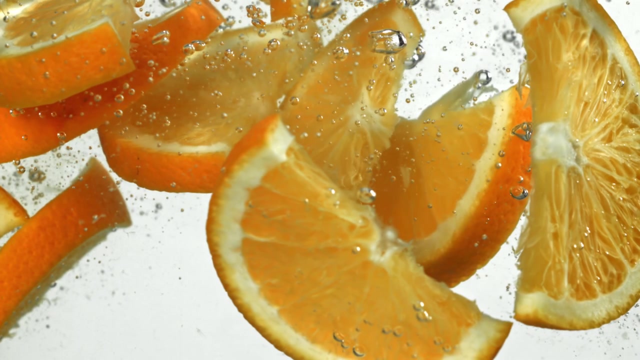 Fette d'arancia vivaci che galleggiano in acqua limpida e frizzante