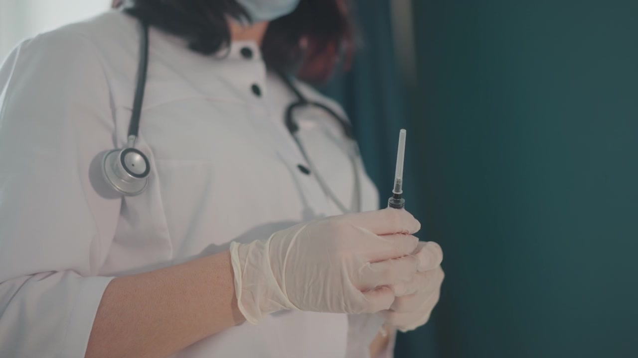 Nurse administering injection at residence. Healthcare professional giving medication during home visit. Medical nurse carefully preparing injection in home setting with focus on safety and precision