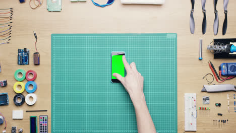 Top-view-hand-gestures-green-screen-smart-phone-technical-desk-from-above---Red-Epic-Dragon