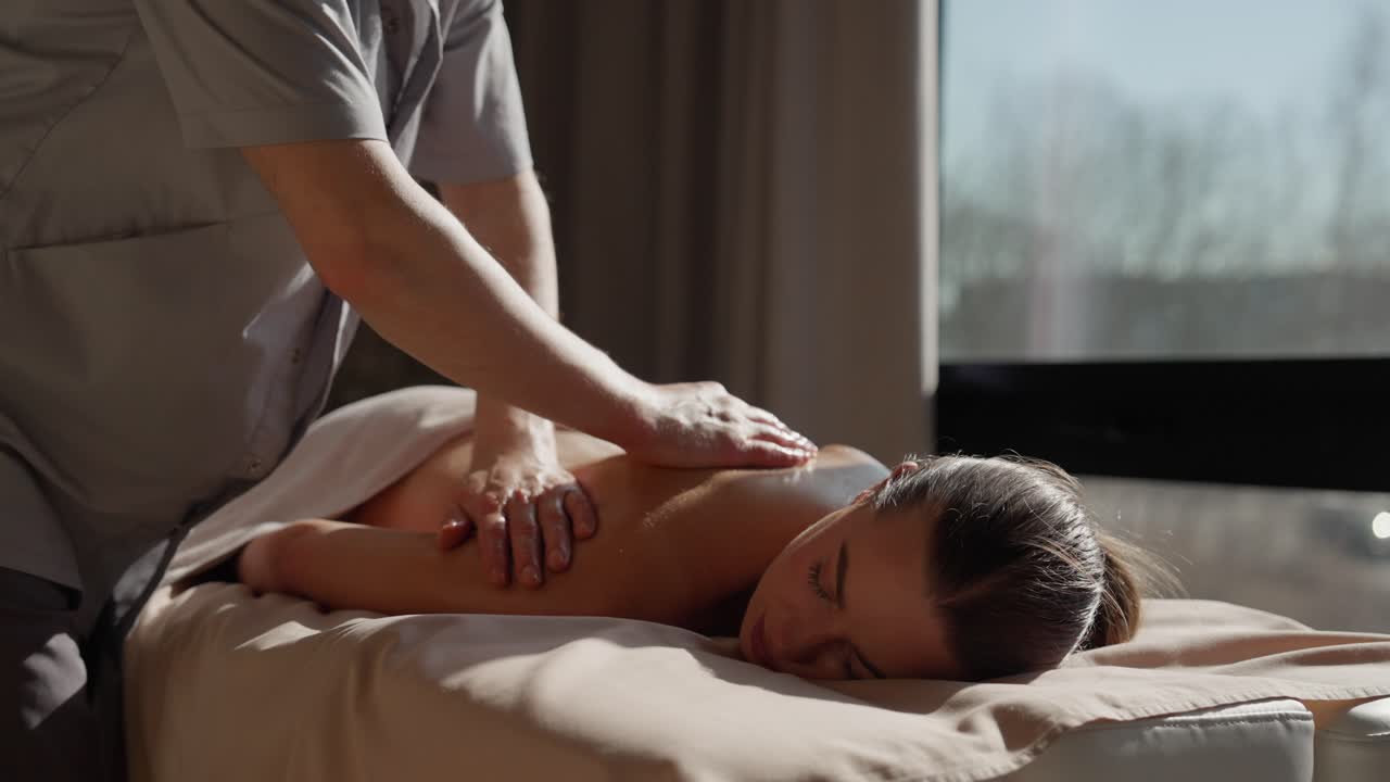 Người phụ nữ đang được mát-xa lưng thư giãn tại spa.