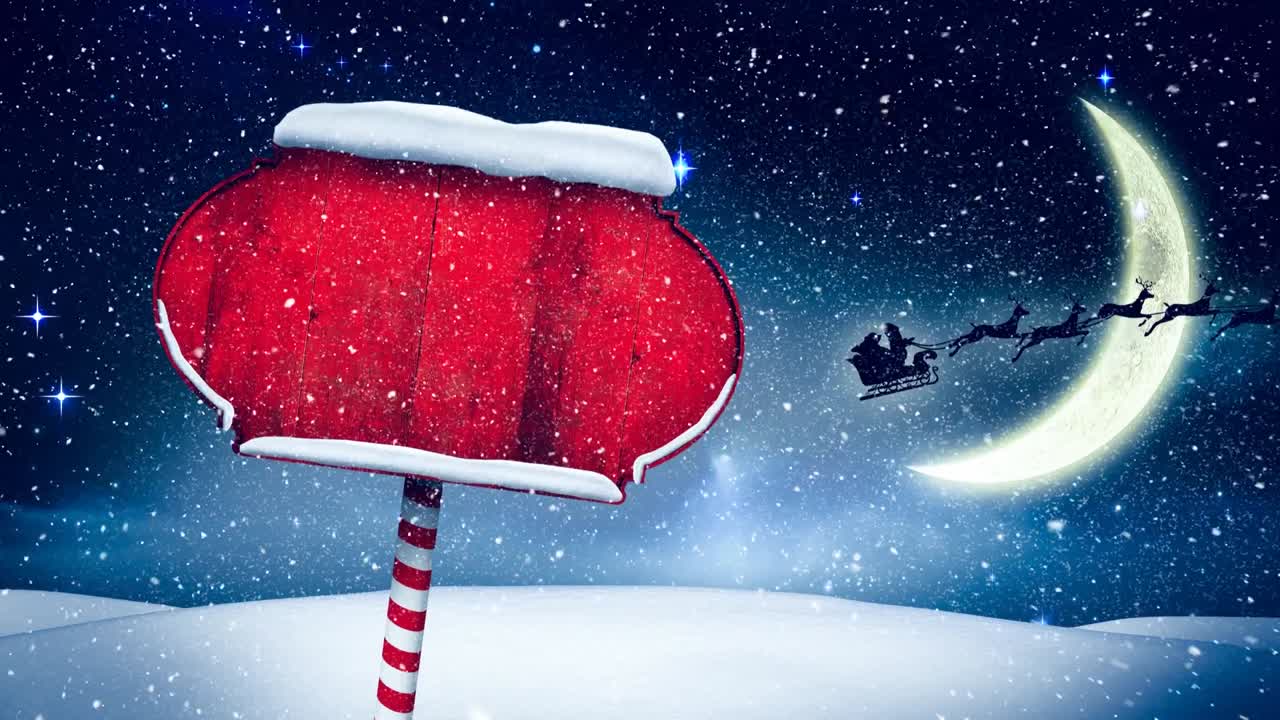 Snow falling over red wooden sign post on winter landscape against moon in the night sky