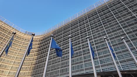 camera pans up from entrance to eu flags at commission building