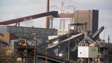 complejo industrial con transportadores y chimeneas, día, que simboliza la industria pesada y la fabricación