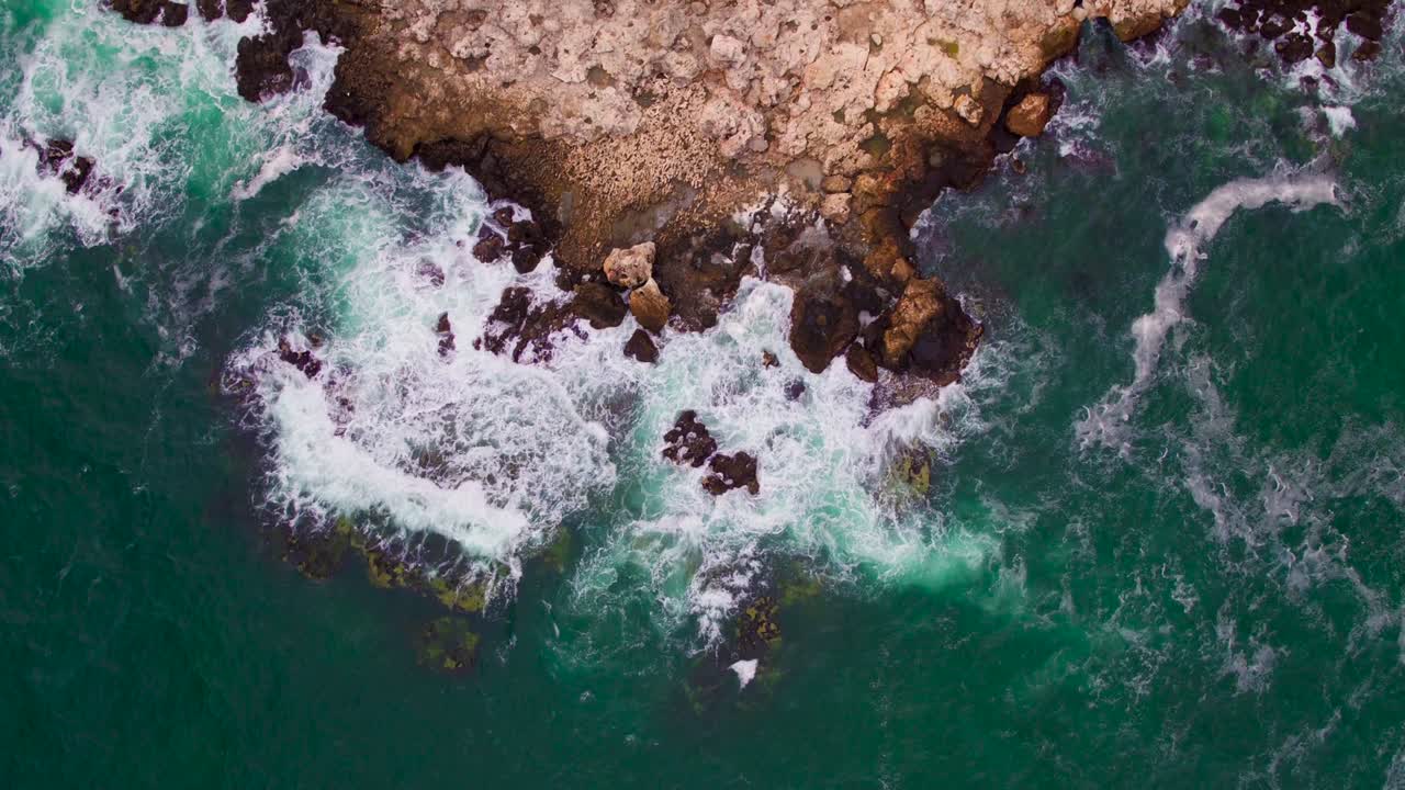 Vista aerea con drone di una costa rocciosa con onde che si infrangono