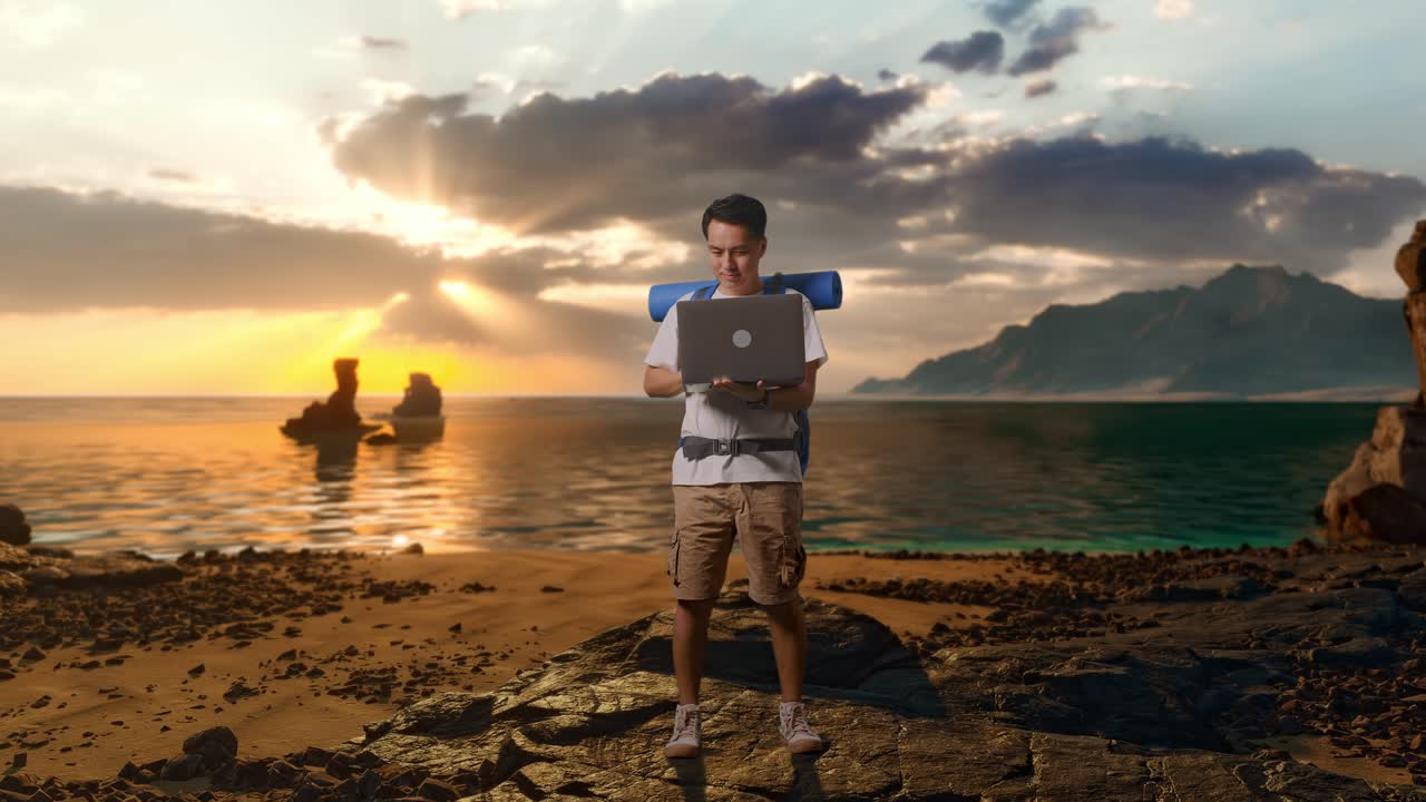 Pendaki Pria Asia dengan Badan Penuh dengan Ransel Gunung Menggunakan Laptop di Pantai
