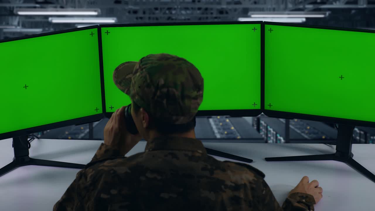 vista de atrás de militares asiáticos bebiendo café y trabajando con simulacro de múltiples monitores de computadora en el centro de datos