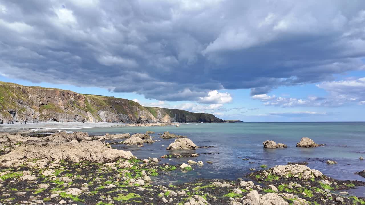 Dramatic Coastal Landscape with Rocky Beach and Cliffs under Cloudy Sky