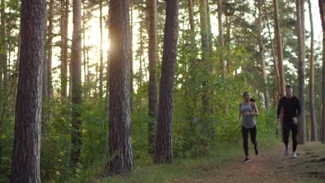 happy couple running together in the forest