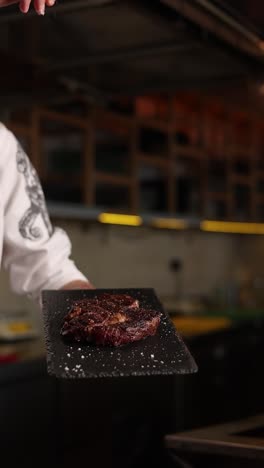 chef seasoning a grilled steak