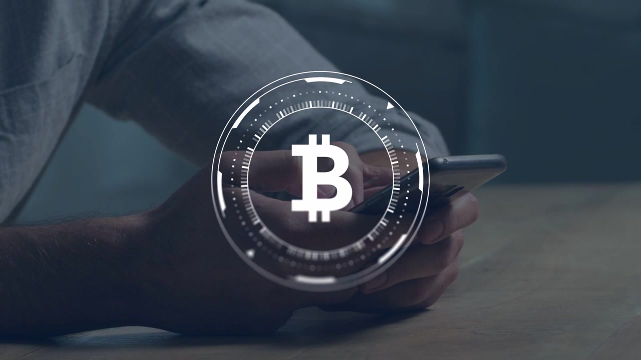 Mand holder smartphone på bordplade, tommelfinger ruller og aktiverer roterende Bitcoin HUD til tegnebog.