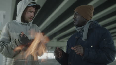 two men experiencing homelessness under a bridge