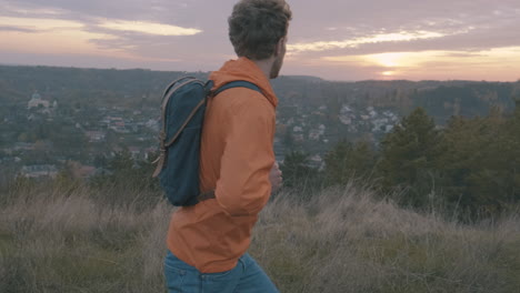 pareja joven de excursionistas femeninos y masculinos en la cima de la montaña hermosa puesta de sol