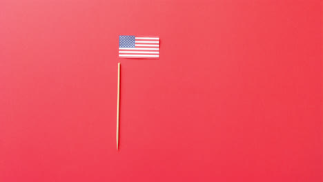 national flag of usa and stick lying on red background with copy space