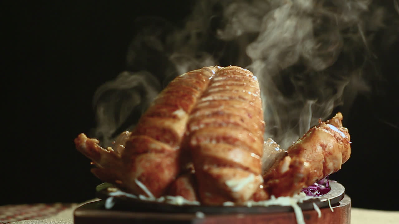 крупный план жареной курицы на круглом столе с дымом черный фон