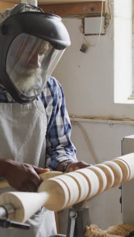 african american man works on a wood lathe in a workshop