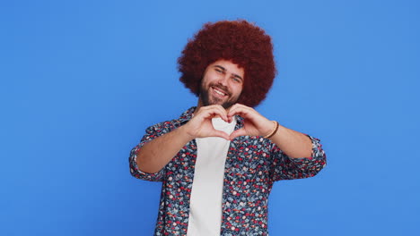 sonriente hombre encantador hace el gesto del corazón demuestra el amor señal expresa buenos sentimientos y simpatía