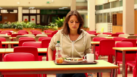 unhappy student eating lunch alone